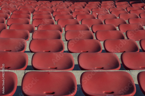 Empty plastic red chairs In outdoor theater in sunny day. Close Up.