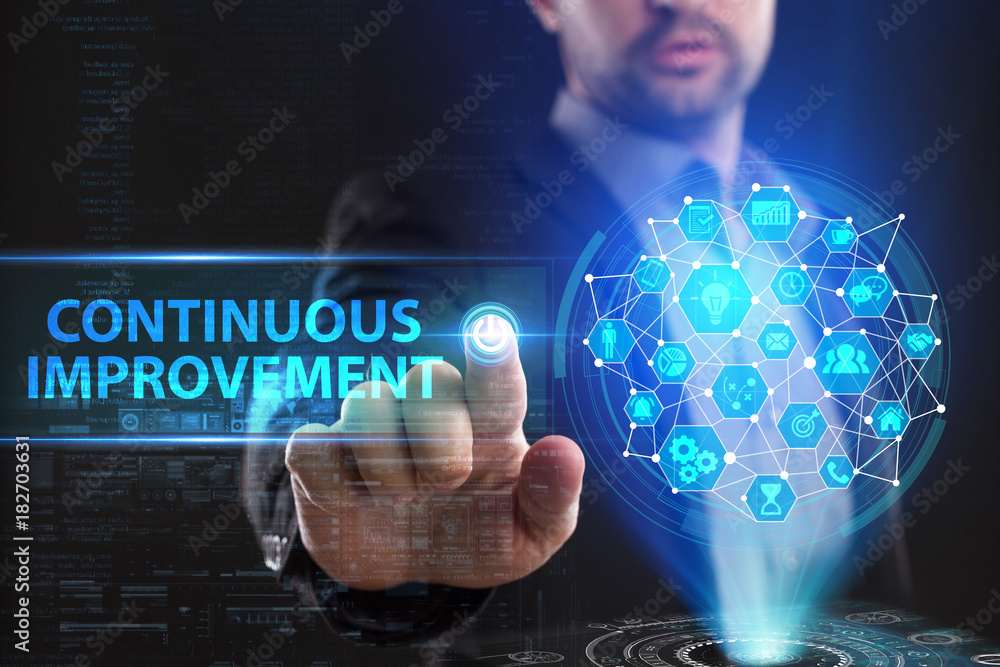 The concept of business, technology, the Internet and the network. A young entrepreneur working on a virtual screen of the future and sees the inscription: Continuous improvement The concept of business, technology, the Internet and the network. A young entrepreneur working on a virtual screen of the future and sees the inscription: Continuous improvement