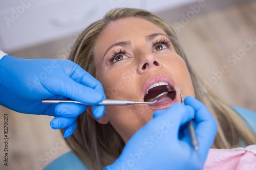 Dentist examining woman at hospital