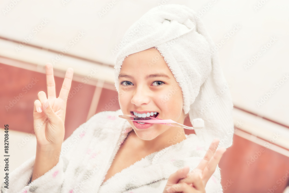 Teenage girl in bathroom with toothbrush. Morning and evening dental hygiene Teenage girl in bathroom with toothbrush. Morning and evening dental hygiene