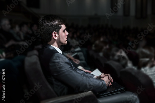 successful businessman sitting on a business conference in the modern conference hall