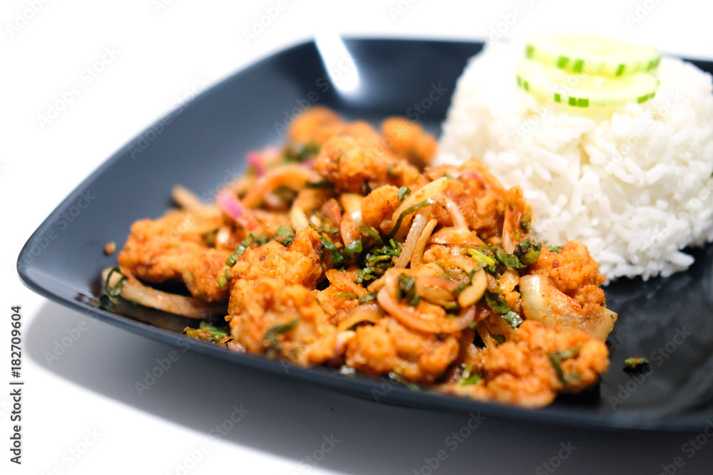 Spicy salad fried chicken with rice in black dish Spicy salad fried chicken with rice in black dish