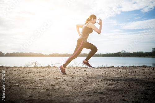 Schilderij op canvas young fitness woman running on the road in the morning.