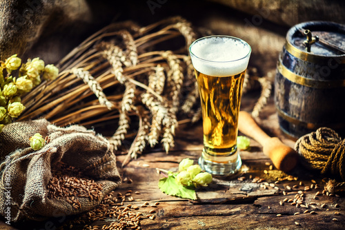 Glass of fresh cold beer in rustic setting. Food and beverage background photo