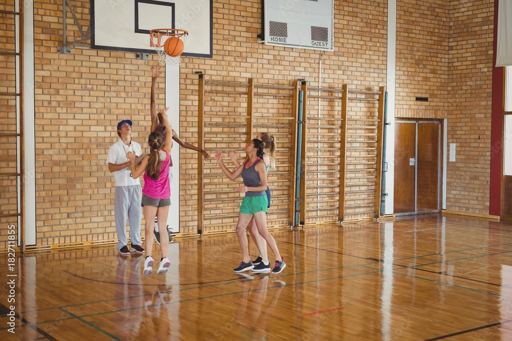 Obraz premium Smiling high school team defending while playing basketball