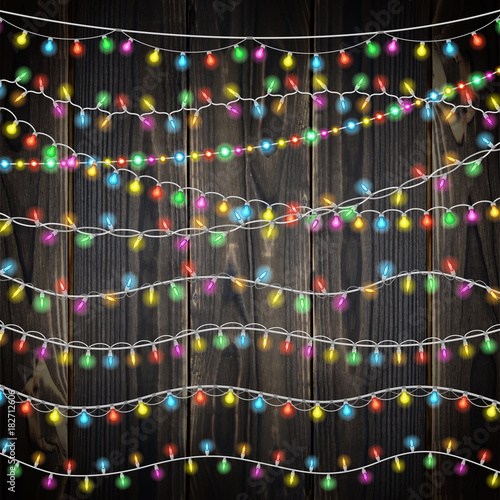 Set of color garland lights. Glowing christmas lights on wooden background. Includes 10 vector brushes festive strands of Christmas lights