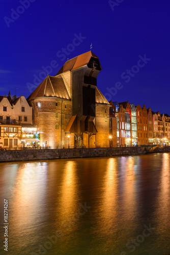 Gdansk at night with famous historic port crane reflected in Motlawa river. Poland, Europe.