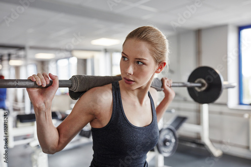 Frau im Fitnesscenter macht Kniebeugen photo