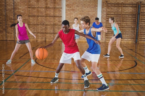 High school kids playing basketball in the court