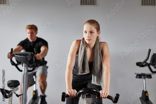 Junge Frau im Spinning Kurs trainiert Ausdauer photo