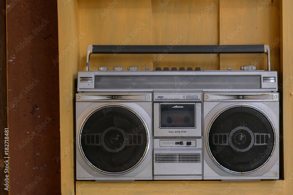 Obraz premium Grey radio tape cassette stereo vintage recorder player with wooden background