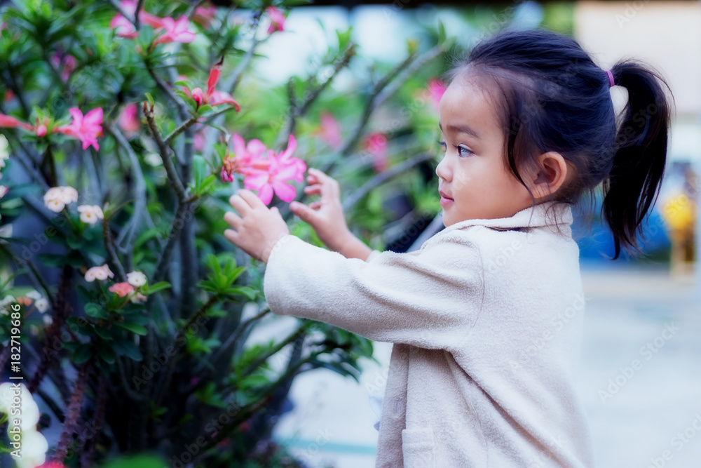 Cute little girl is blossoming flowers blooming in a bright winter day. Cute little girl is blossoming flowers blooming in a bright winter day.