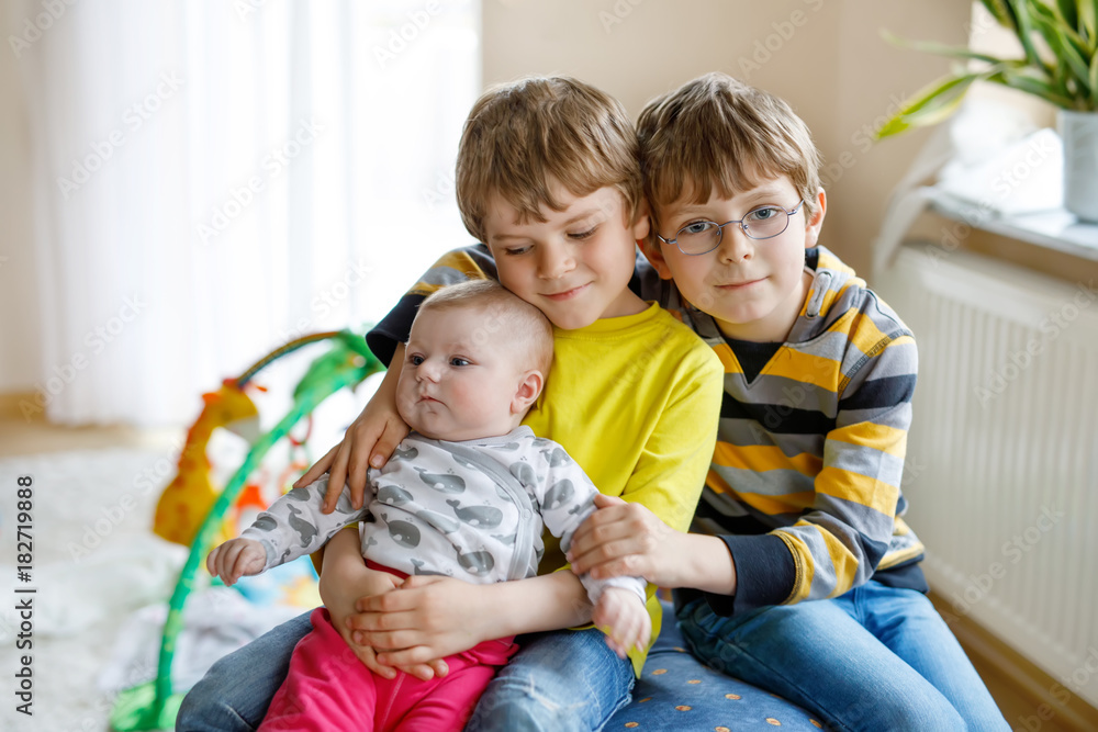 Two little happy kid boys with newborn baby girl, cute sister. Two little happy kid boys with newborn baby girl, cute sister.