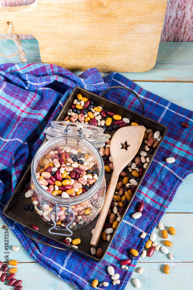 Fototapeta premium Beans mix in the jar and tray. Blue wooden table and background.