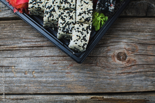 Sushi in a black container on a wooden table colorful and beautiful photo