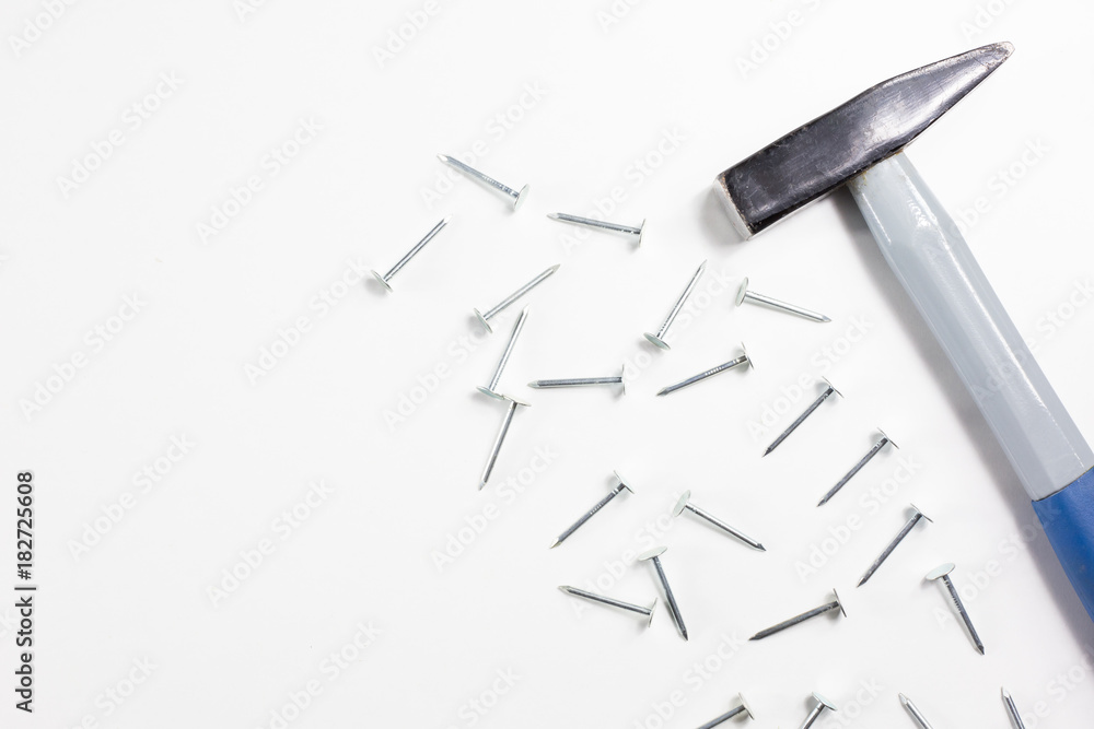 Nails and hammer on a white background, tools, industrial concept Nails and hammer on a white background, tools, industrial concept