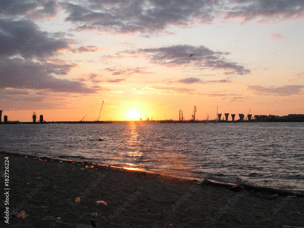 Naklejka premium Great building bridge over the river, building cranes bridge support at sunset