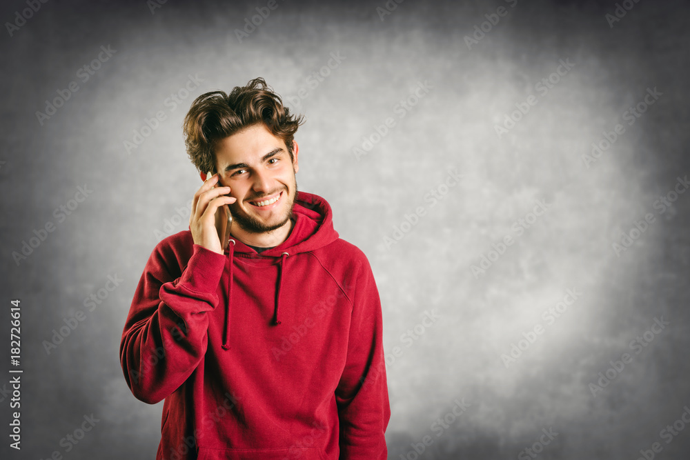 Smiling young man with beard talking on cellphone
Smiling young man with beard talking on cellphone