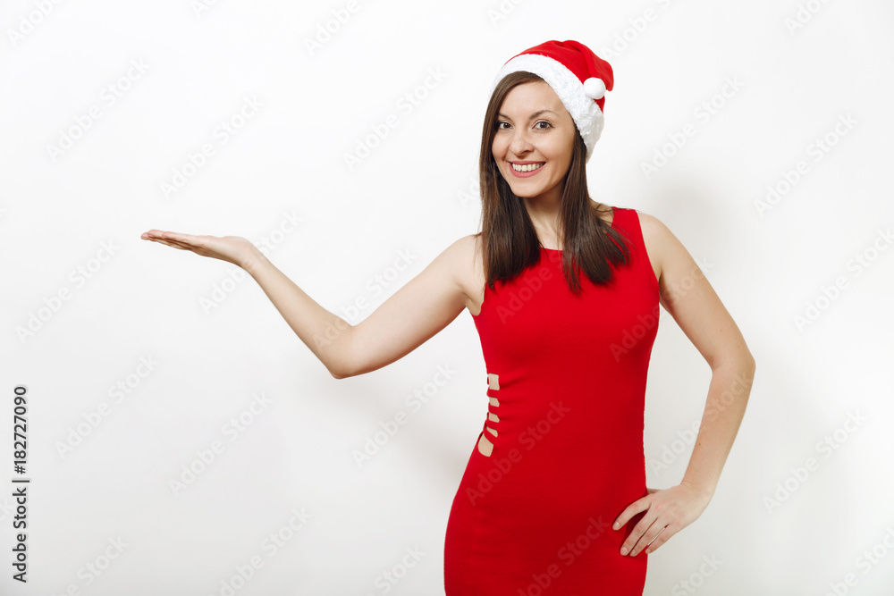 Pretty caucasian happy woman with charming smile wearing red dress and Christmas hat looking camera, holding copy space on palm isolated on white background. Santa girl. New Year holiday 2018 concept Pretty caucasian happy woman with charming smile wearing red dress and Christmas hat looking camera, holding copy space on palm isolated on white background. Santa girl. New Year holiday 2018 concept