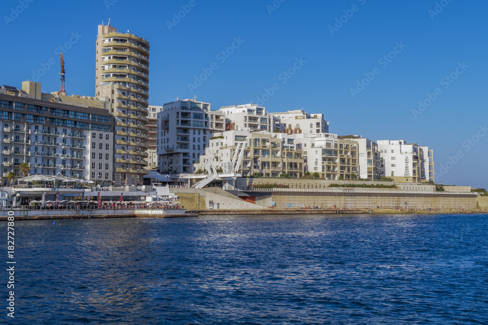 Sliema, Malta landscape day city view. Panoramic day view with modern buildings by the waterfront promenade, viewed from Valletta. Sliema, Malta landscape day city view. Panoramic day view with modern buildings by the waterfront promenade, viewed from Valletta.