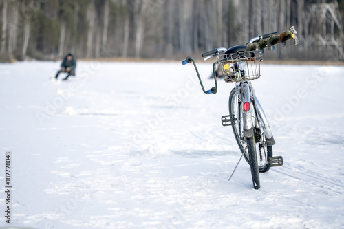 bike on winter fishing, a fisherman in the background out of foсus