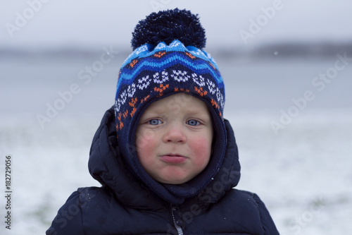 Toddler with snivel and red cheeks. Outdoor winter shot photo