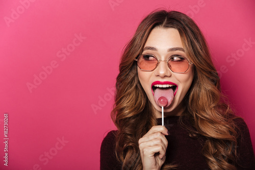 Beautiful lady wearing glasses eating candy.