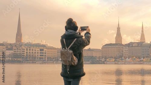 Tourist takes pictures of Alster Lake and Hamburg city panorama