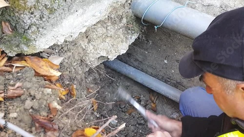 A worker man  makes a pit to empty old pipes for plumbing. photo