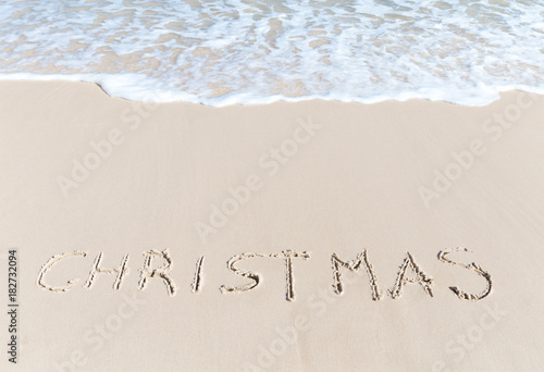 Christmas sign on the beach sand tropical hot winter concept