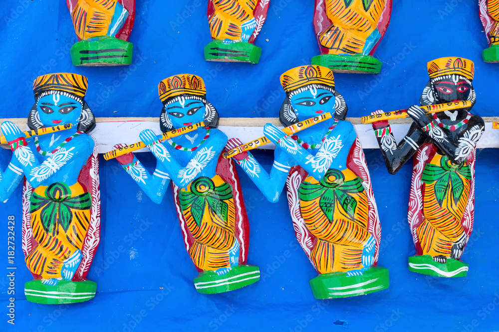 Wooden idols of Lord Krishna, handicrafts on display.