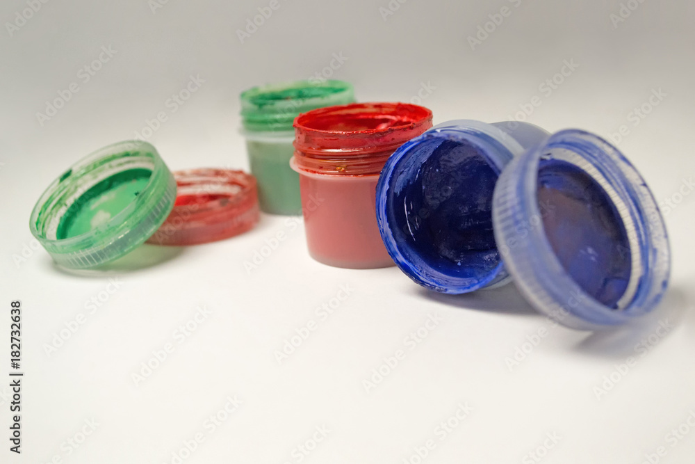 Multicolored gouache in jars on white background Multicolored gouache in jars on white background
