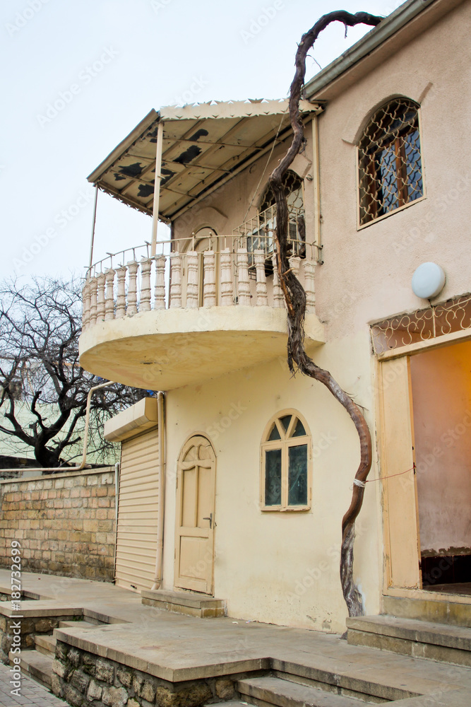 View at the Sabir Street and old building with round balcony. Walking on empty, morning street in old city of Baku. Ancient stone buildings.