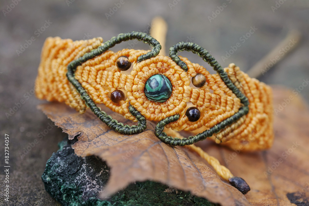 Obraz premium Macrame material handmade bracelet on natural background