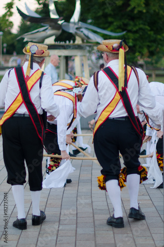 Traditional morris men dancing in the UK with sticks bells and musical instrument