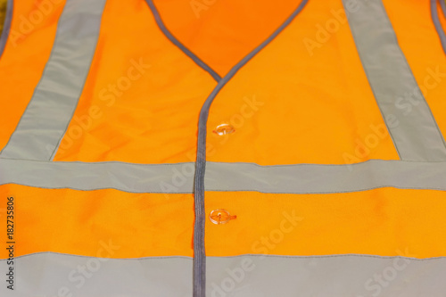 Protective waistcoat in orange with reflective stripes. photo