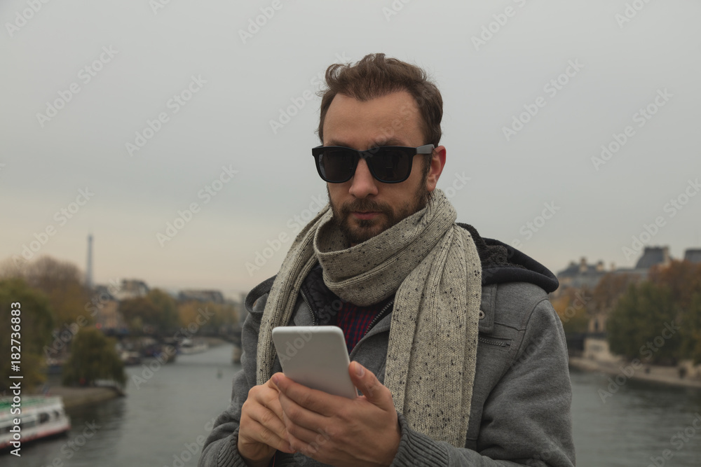 Modern guy using cellphone in the European city. Modern guy using cellphone in the European city.