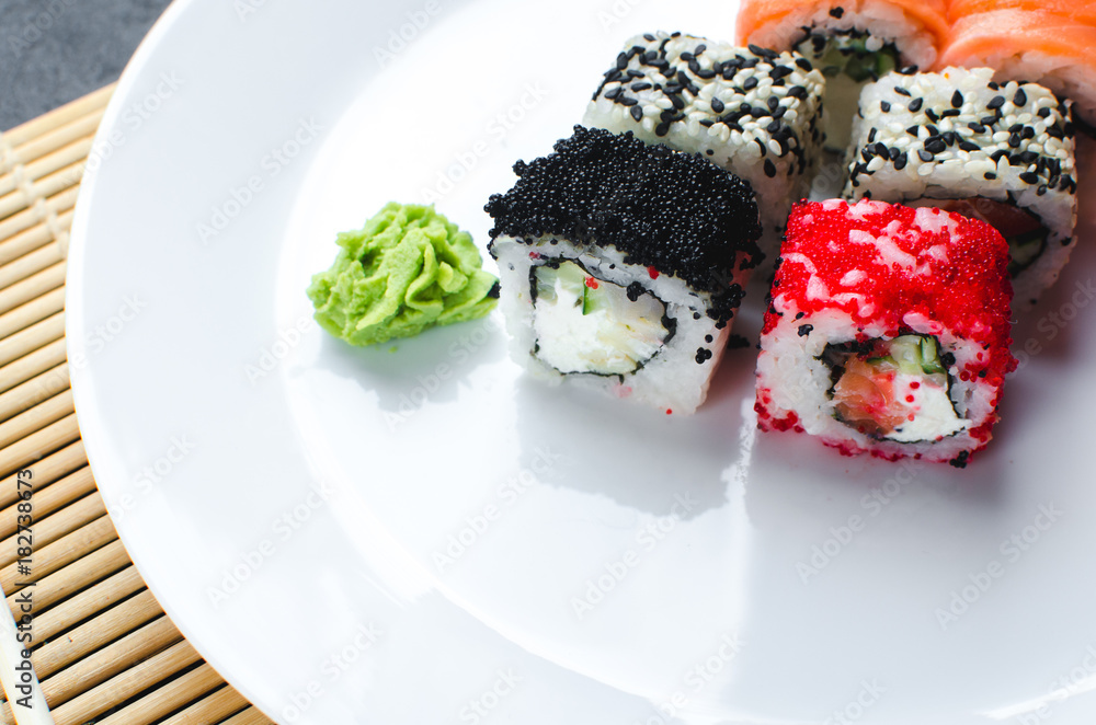on the plate is white, lined with different rolls, sushi on the plate is white, lined with different rolls, sushi