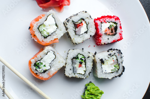 on the plate is white, lined with different rolls, sushi photo