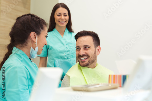 Portrait of a female dentist and young man in a dentist office