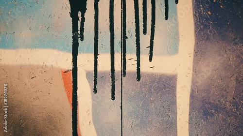 Extremely closeup Shot of black paint flows down the colored wall