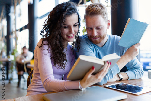 Young couple reading books in coffee shop