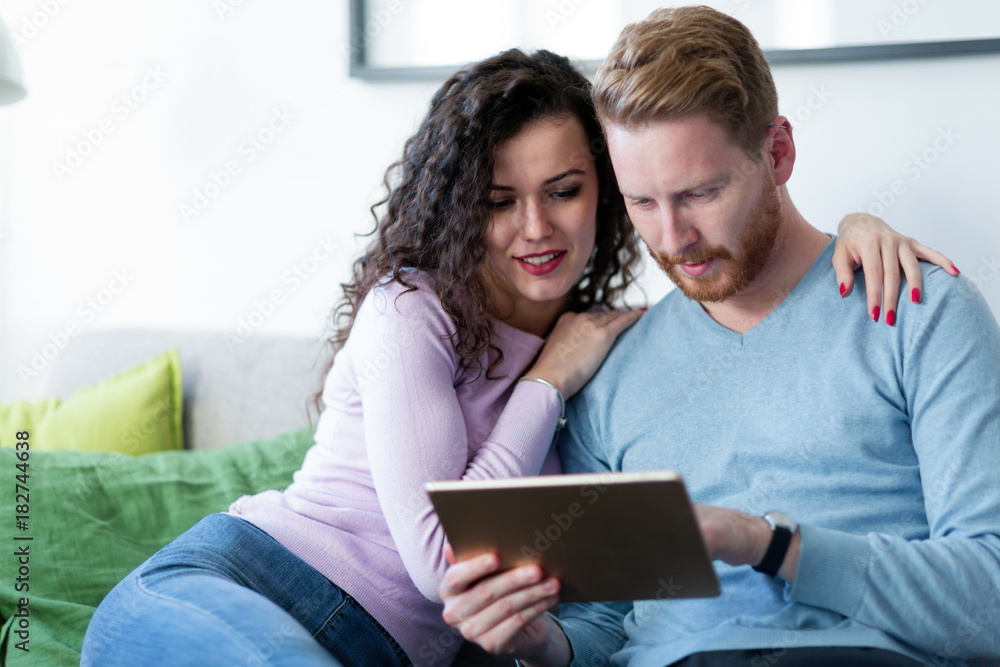 Young couple using digital tablet at home Young couple using digital tablet at home