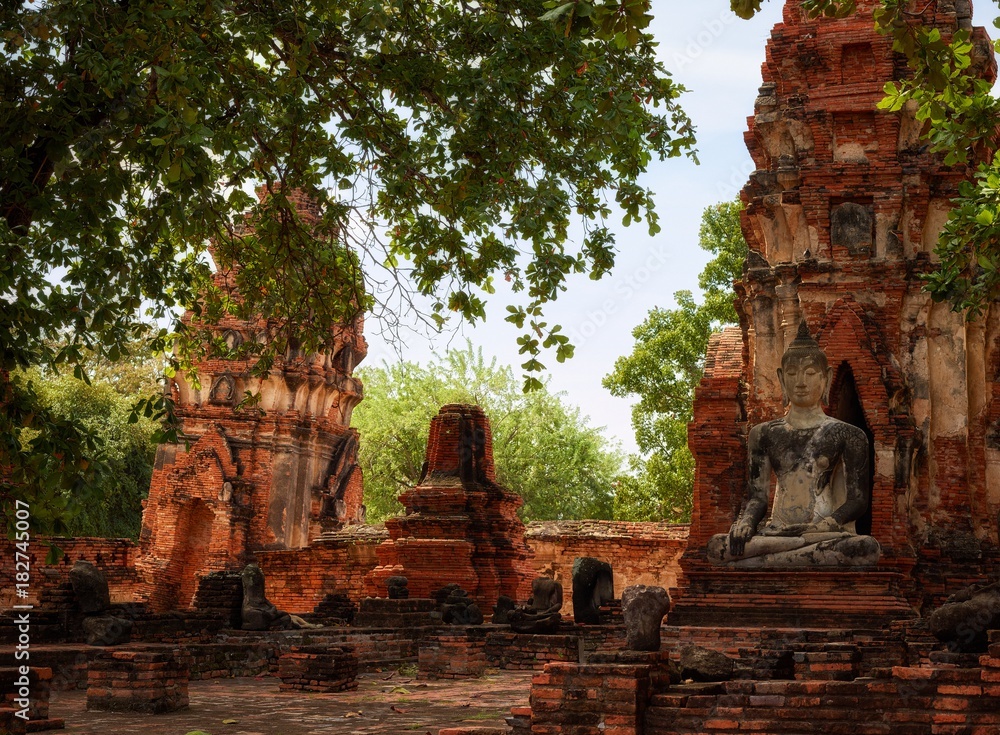 Statue of Buddha and Prang in ruines of  Wat Mahathat (Temple of the Great Relic)