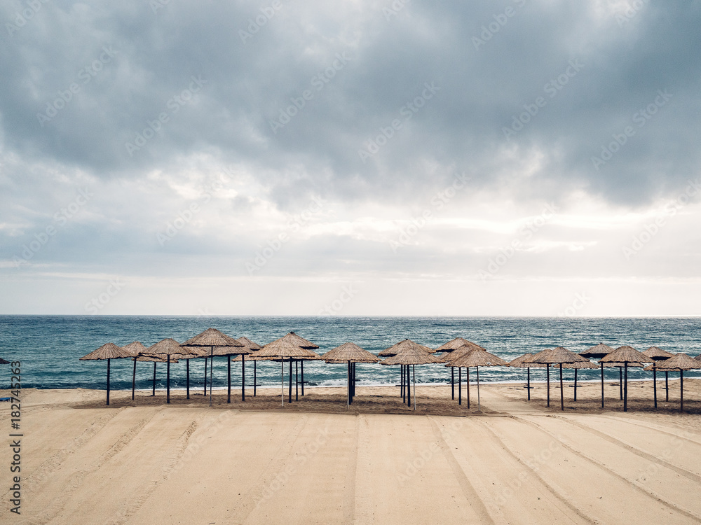 Aufgereihte Sonnenschirme an menschenleerem Strand Aufgereihte Sonnenschirme an menschenleerem Strand