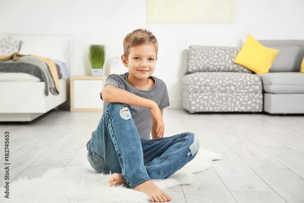 Cute little boy sitting on floor at home Cute little boy sitting on floor at home
