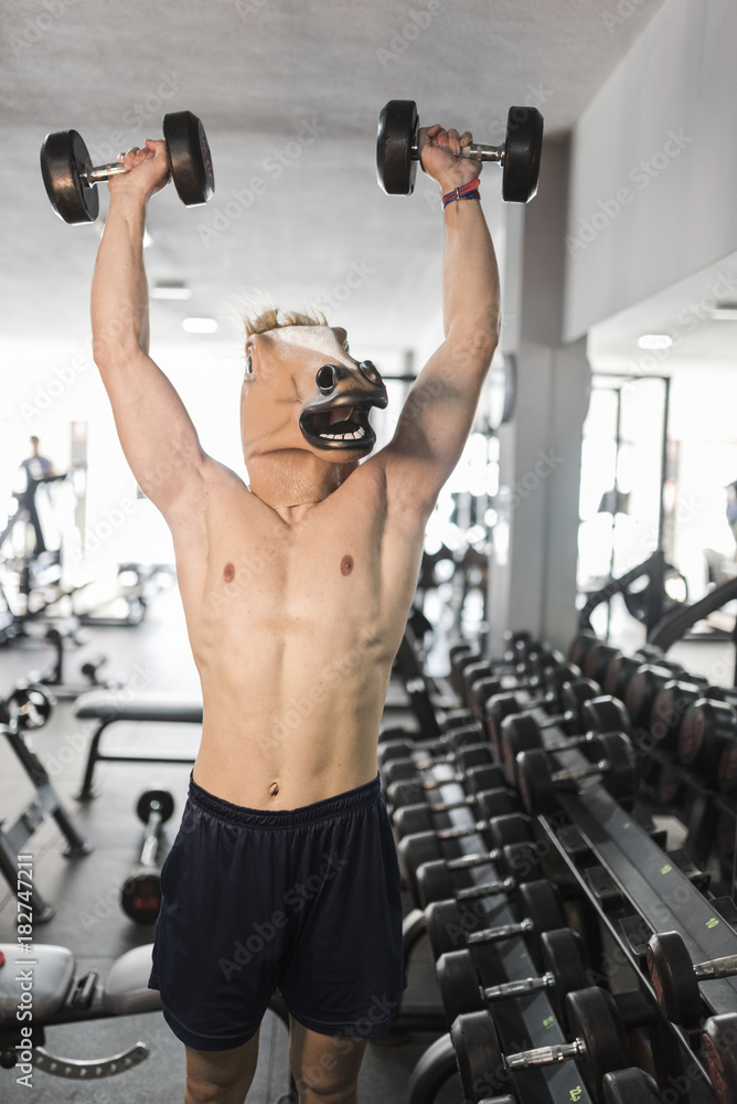Horse face man training shoulder exercises in gym Horse face man training shoulder exercises in gym