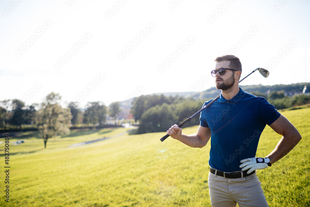 Full length view of man in cap holding golf club and hitting ball on green lawn Full length view of man in cap holding golf club and hitting ball on green lawn