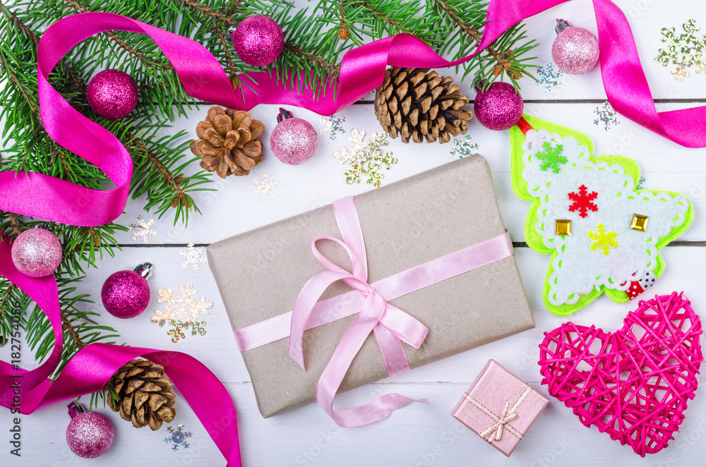 Christmas background with decorations and a gift box on a wooden white table, top view. Christmas background with decorations and a gift box on a wooden white table, top view.