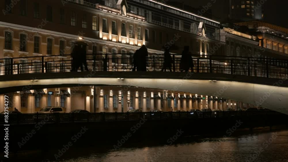 Silhouettes of people who walk on the bridge in the evening. City life. Silhouettes of people who walk on the bridge in the evening. City life.